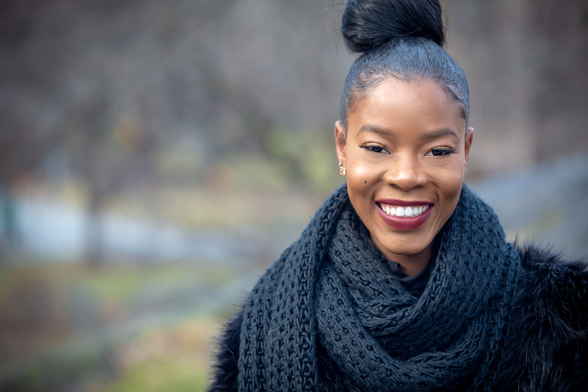 Cheerful black woman standing in park